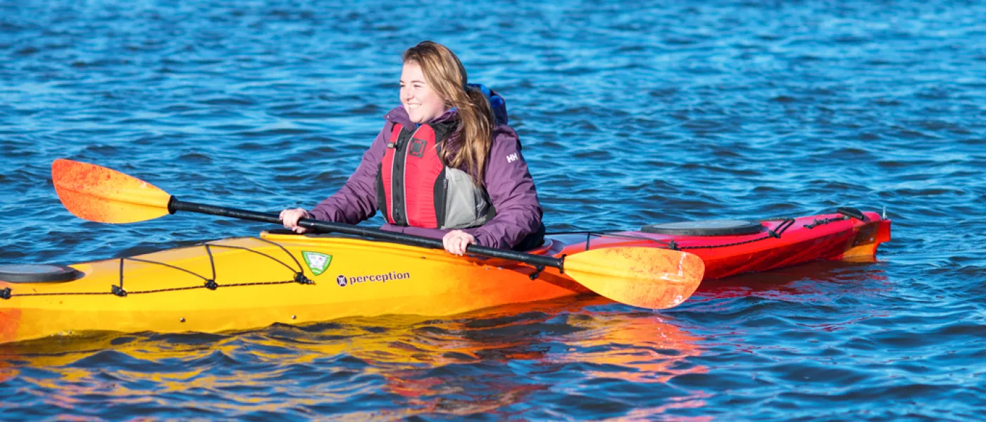 A student kayaks in a river