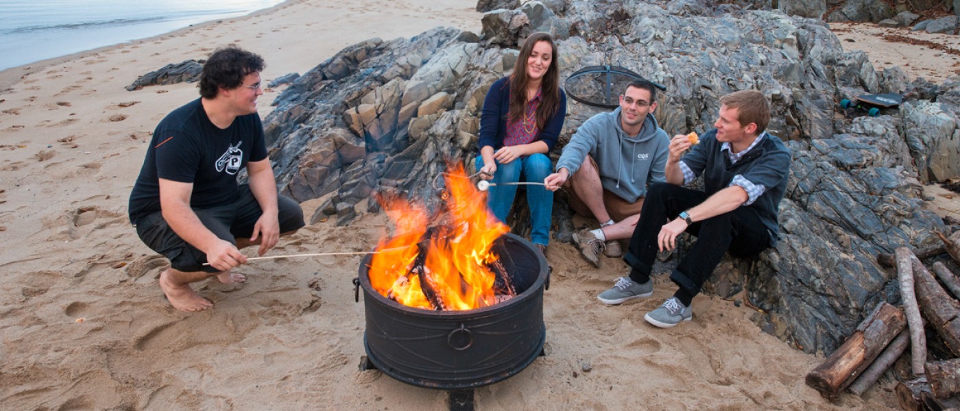 Four students having a bon fire on Freddy Beach