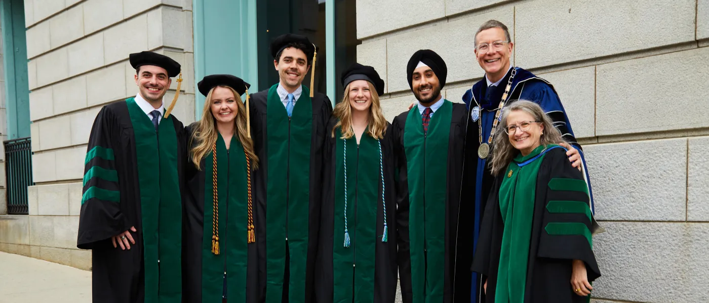 UNE COM graduates, President Herbert, and COM Dean Jane Carreiro pose at Merrill Auditorium in Portland