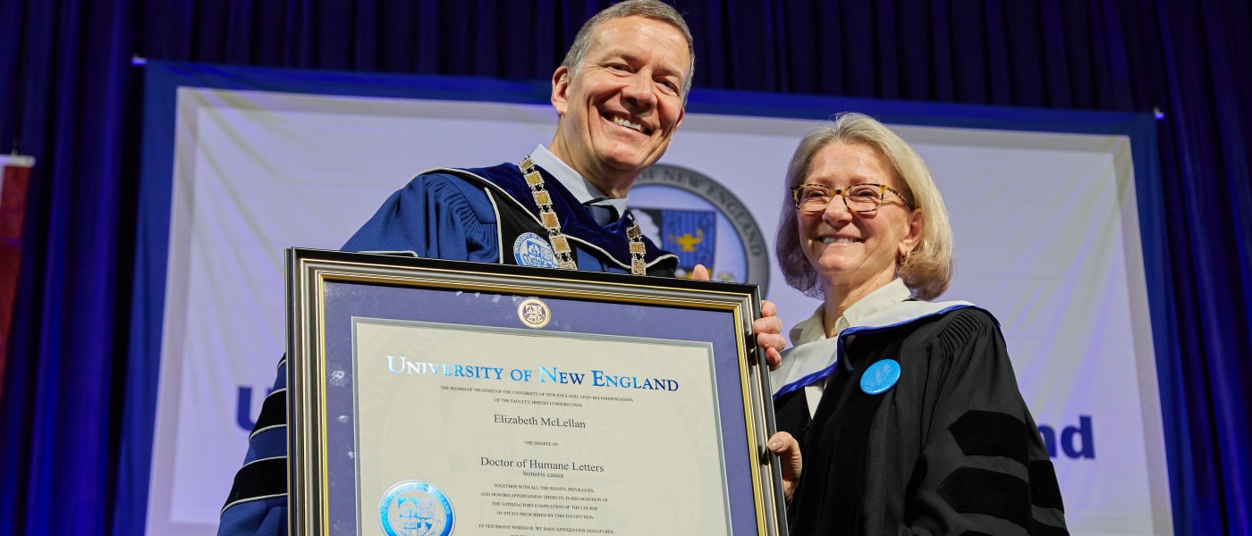 UNE President James Herbert holds an honorary degree awarded to Elizabeth McLellan