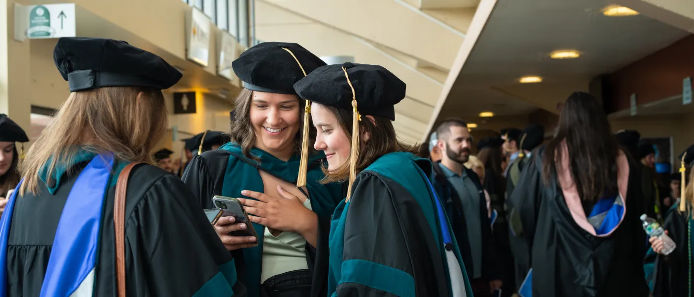 UNE graduates take photos at the Cross Insurance Arena in Portland