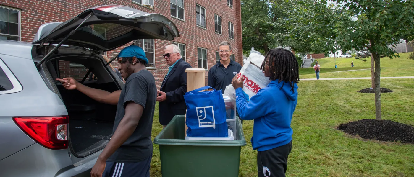 UNE President James Herbert and Vice President John Tumiel help students unpack