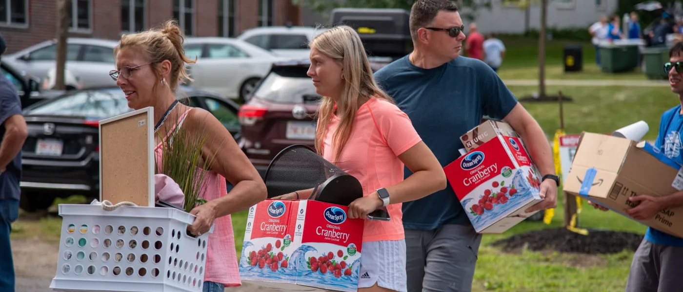 A family moves belongings across the quad