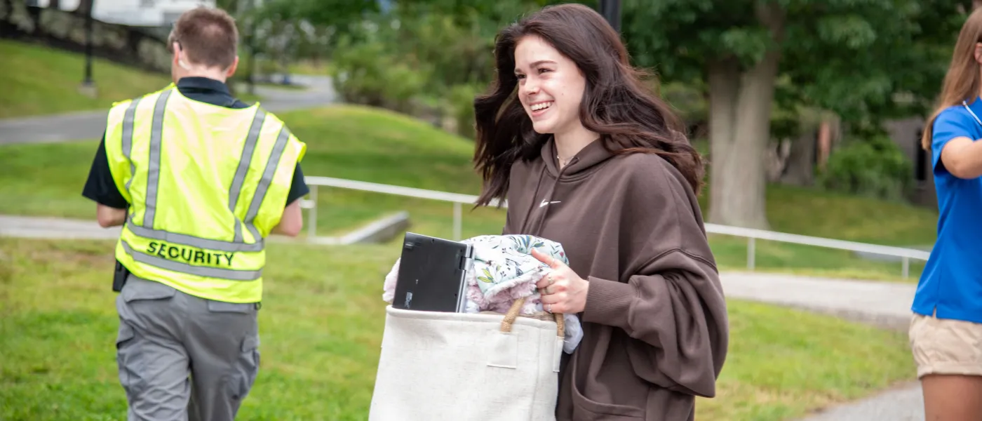 A student carries her belongings across the quad