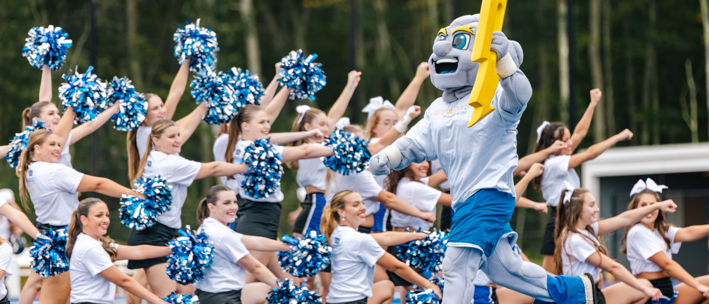 UNE mascot Stormin' Norman high-fives members of the dance team