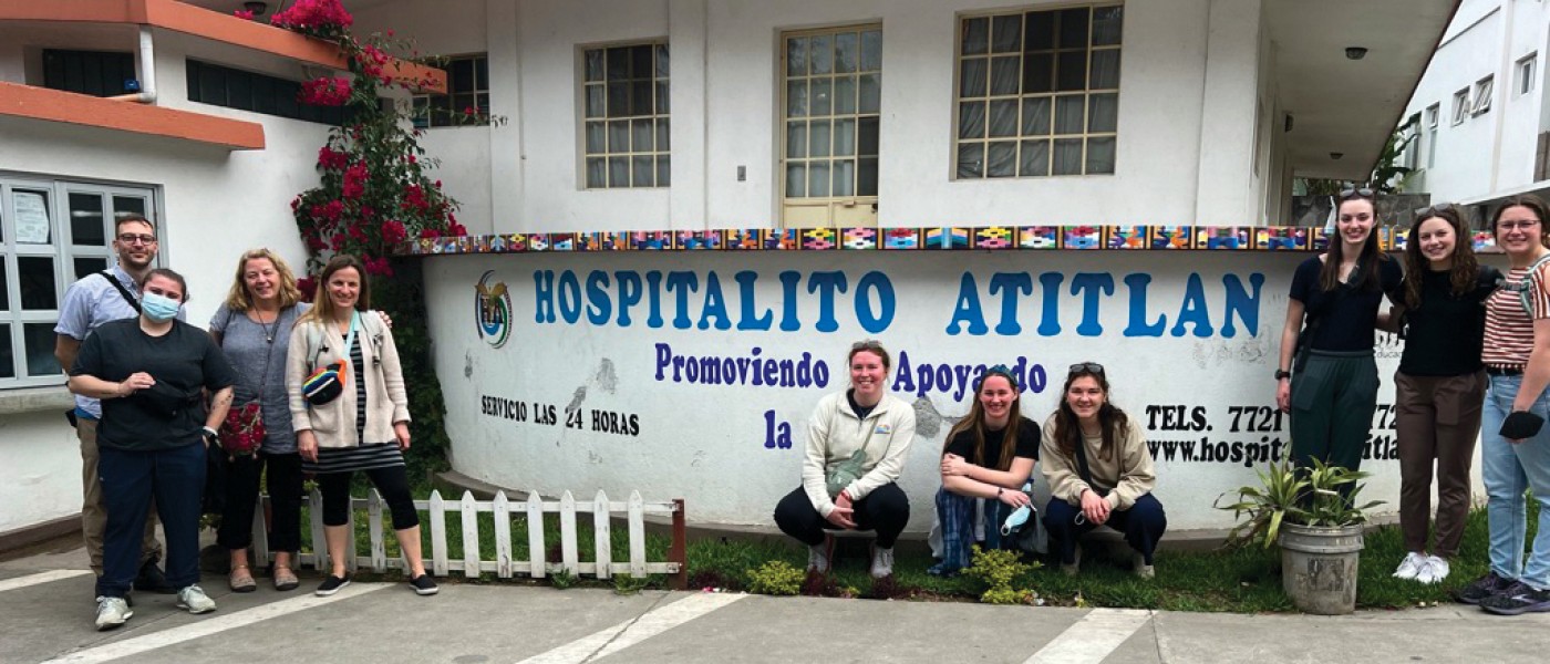 A group of students sit in front of a hospital building in Guatemala