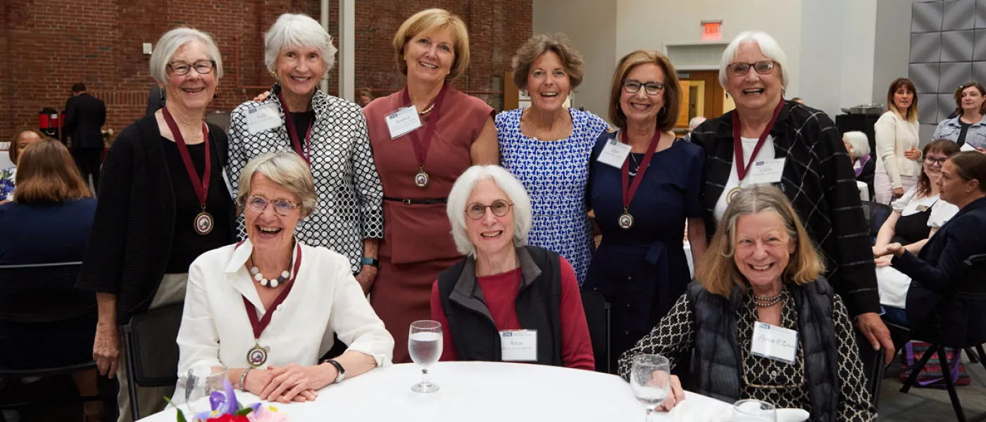 Trish Riley and Andrea Cianchette Maker take a photo with a gorup of U N E faculty
