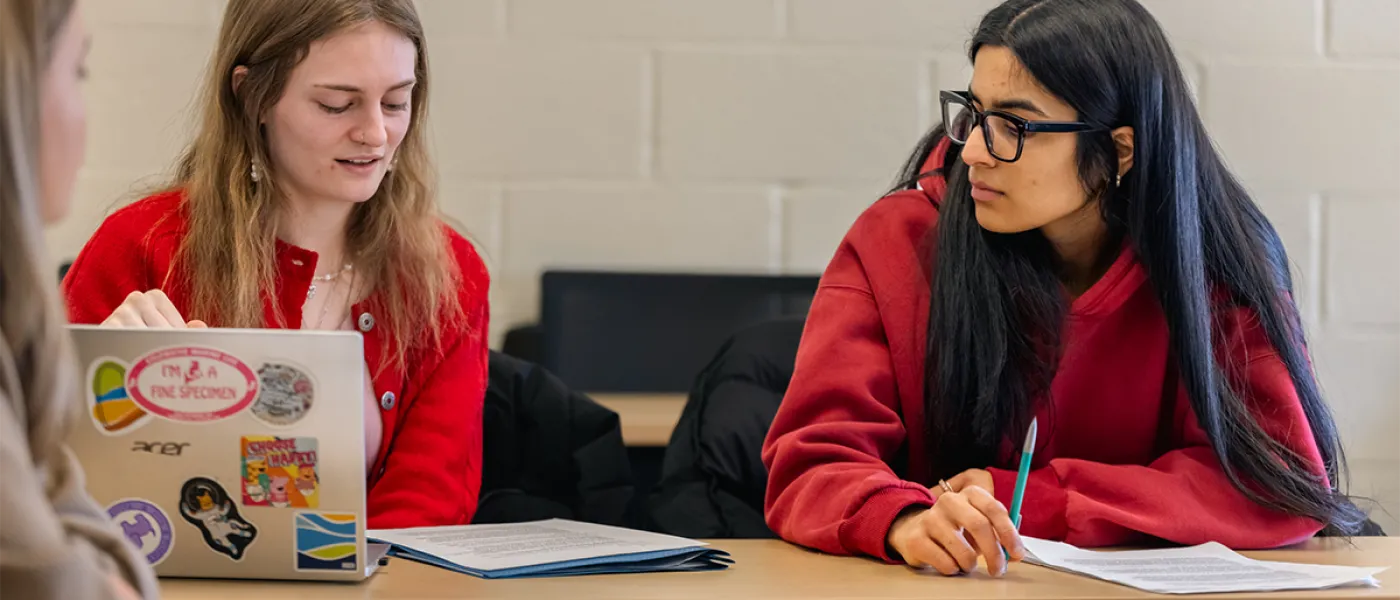 A student listens intently as another student speaks their points during a class discussion