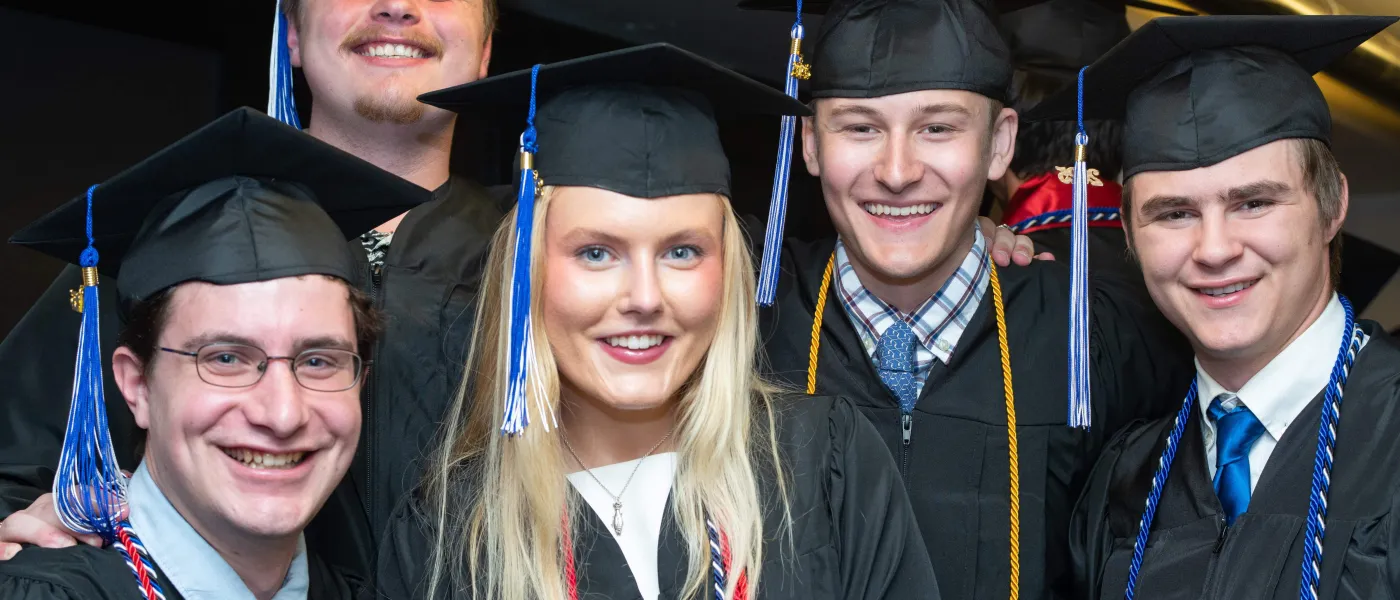 Graduates pose in their caps and gowns