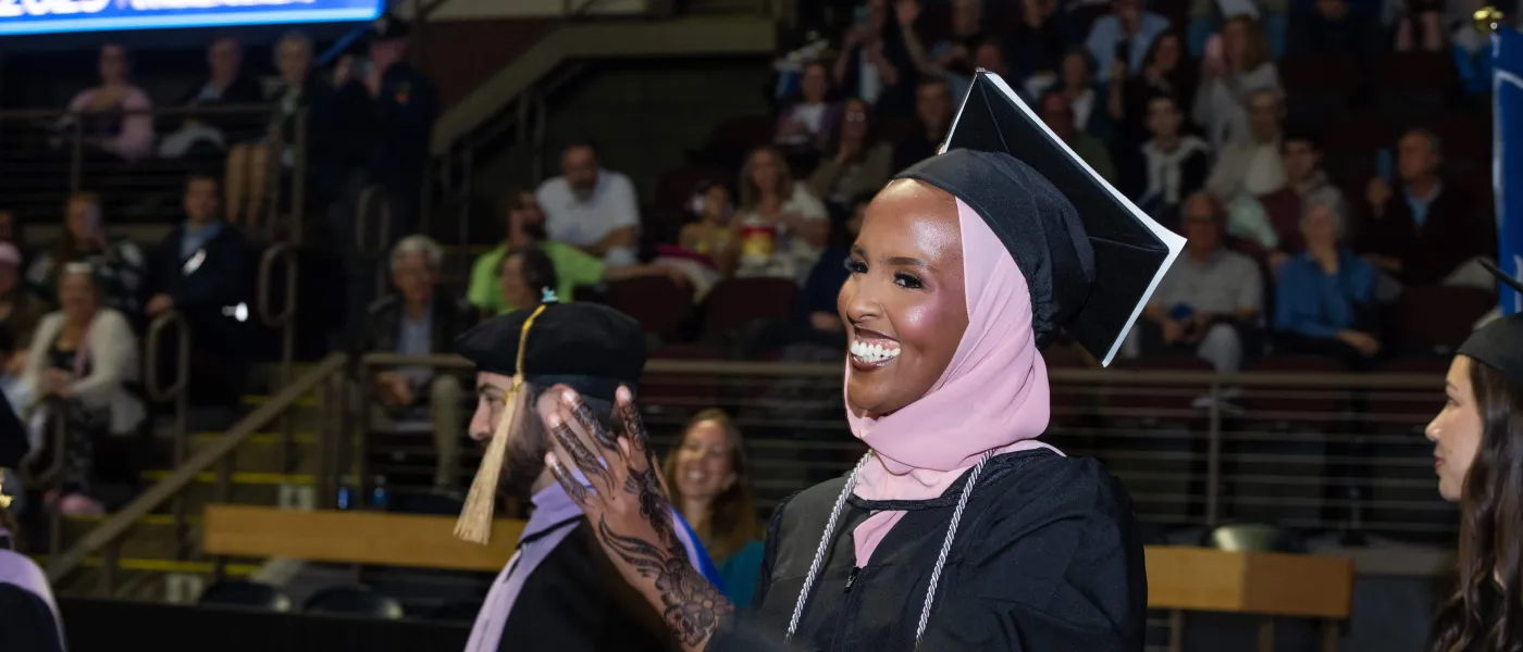 A graduating student claps during the ceremony