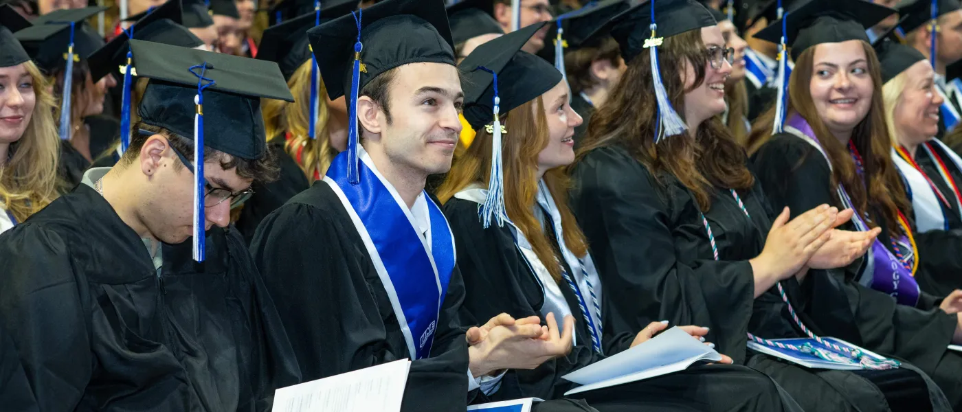 Graduating students clap during the ceremony at the Cross Insurance Arena