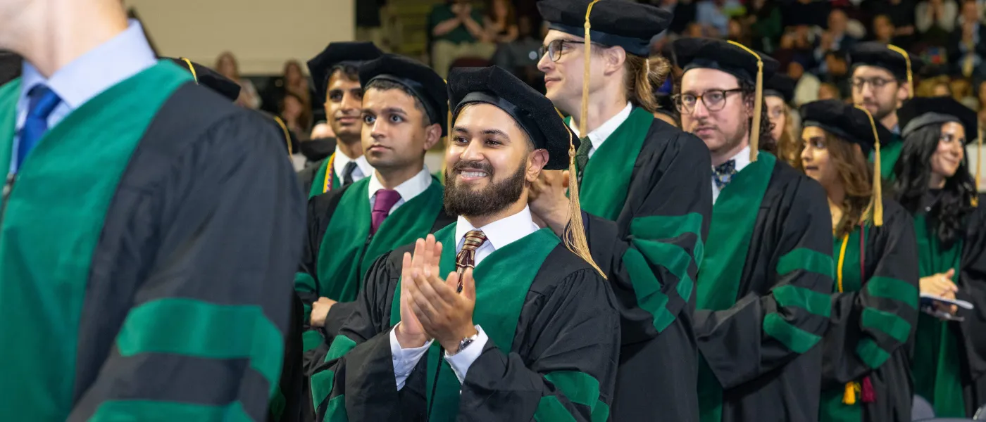 Graduating medical students clap during the ceremony at the Cross Insurance Arena
