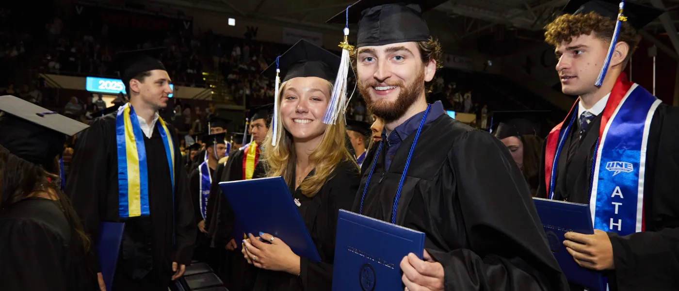 College of Arts and Sciences graduates pose with their diplomas
