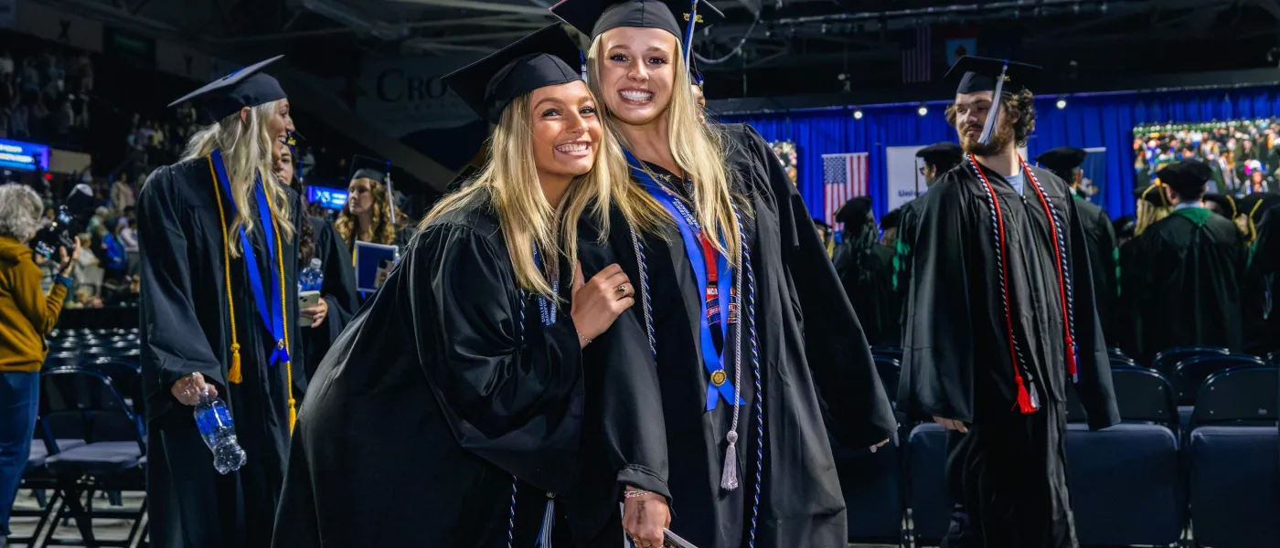 Graduating students pose for a photo inside the arena