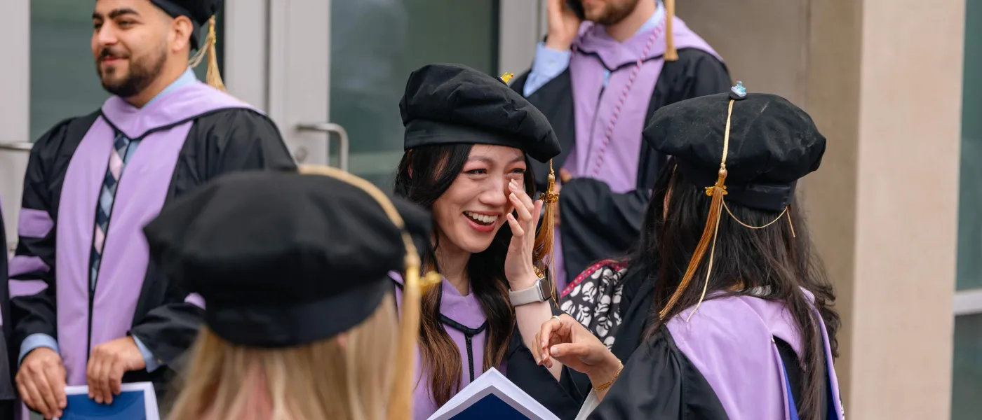 A dental medicine graduate tears up outside UNE's Girard Innovation Hall following the College of Dental Medicine graduation ceremony