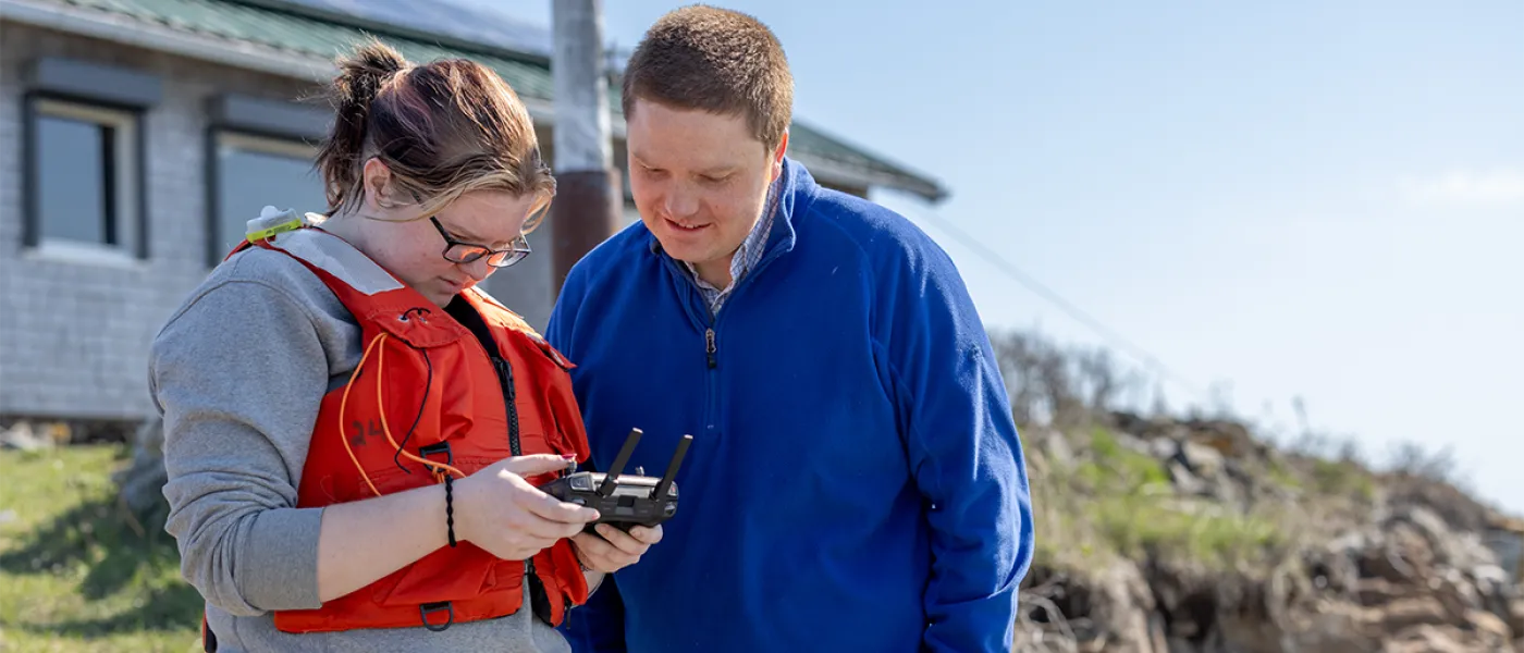 Two students stand together on an island and review the controls for a raspberry shake device