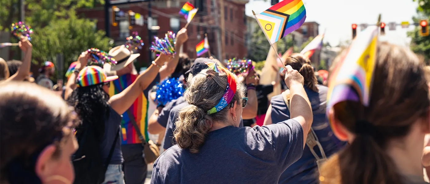 A group of U N E employees and students walking a Pride Parade in Maine