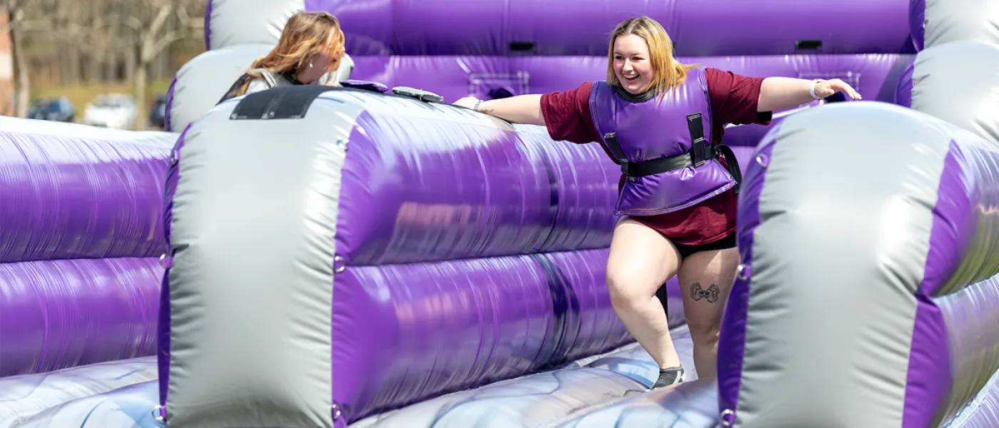 Two students race through a blow-up obstacle course