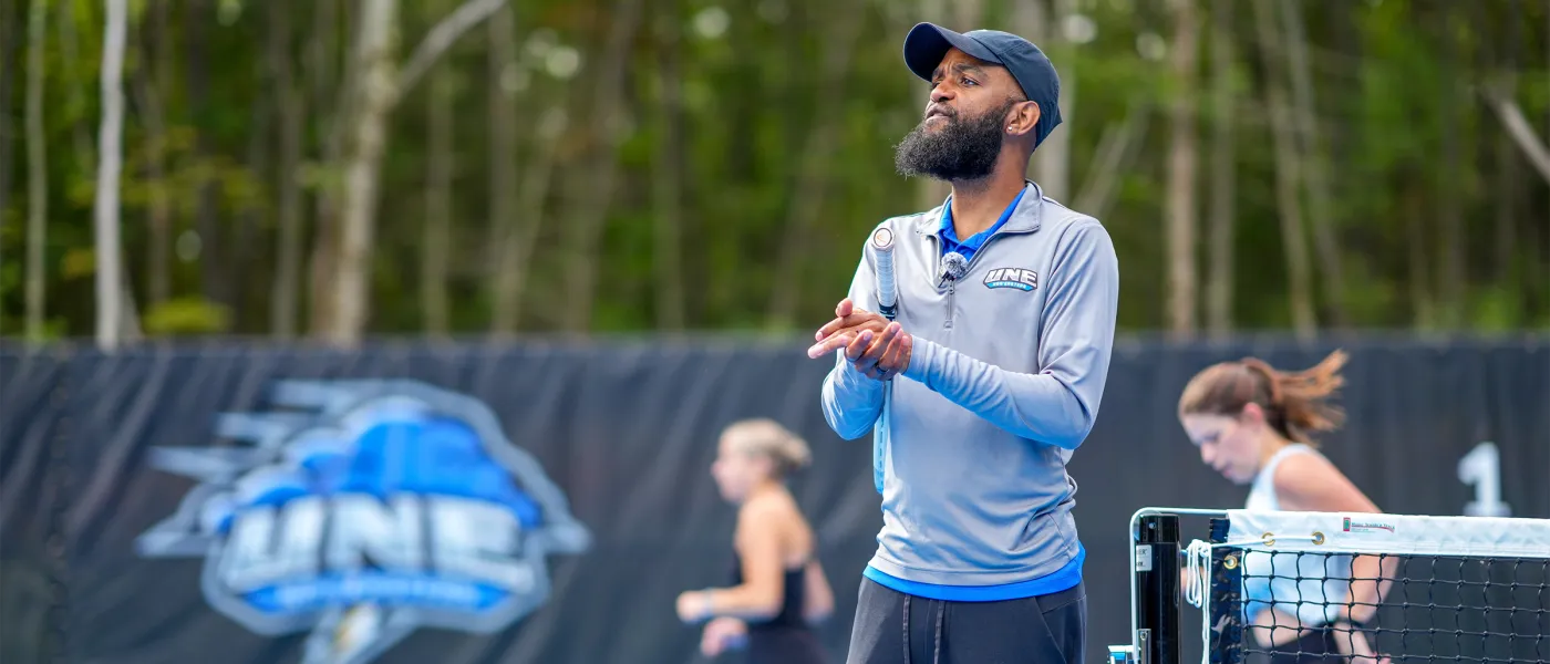 Coach Jovan Jordan-Whitter claps while shouting across the Blue Cyclone Complex.