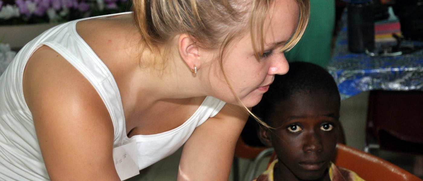 A U N E volunteer examines children in Ghana 