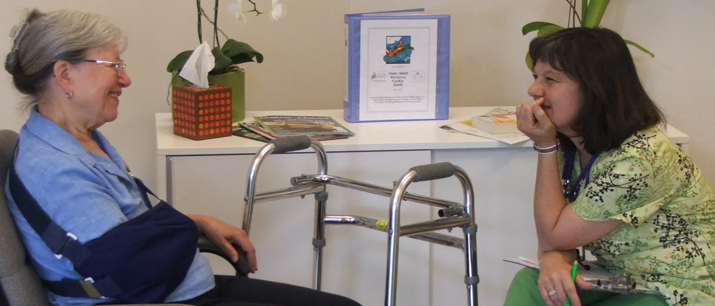 A U N E clinician talks with an elderly patient 