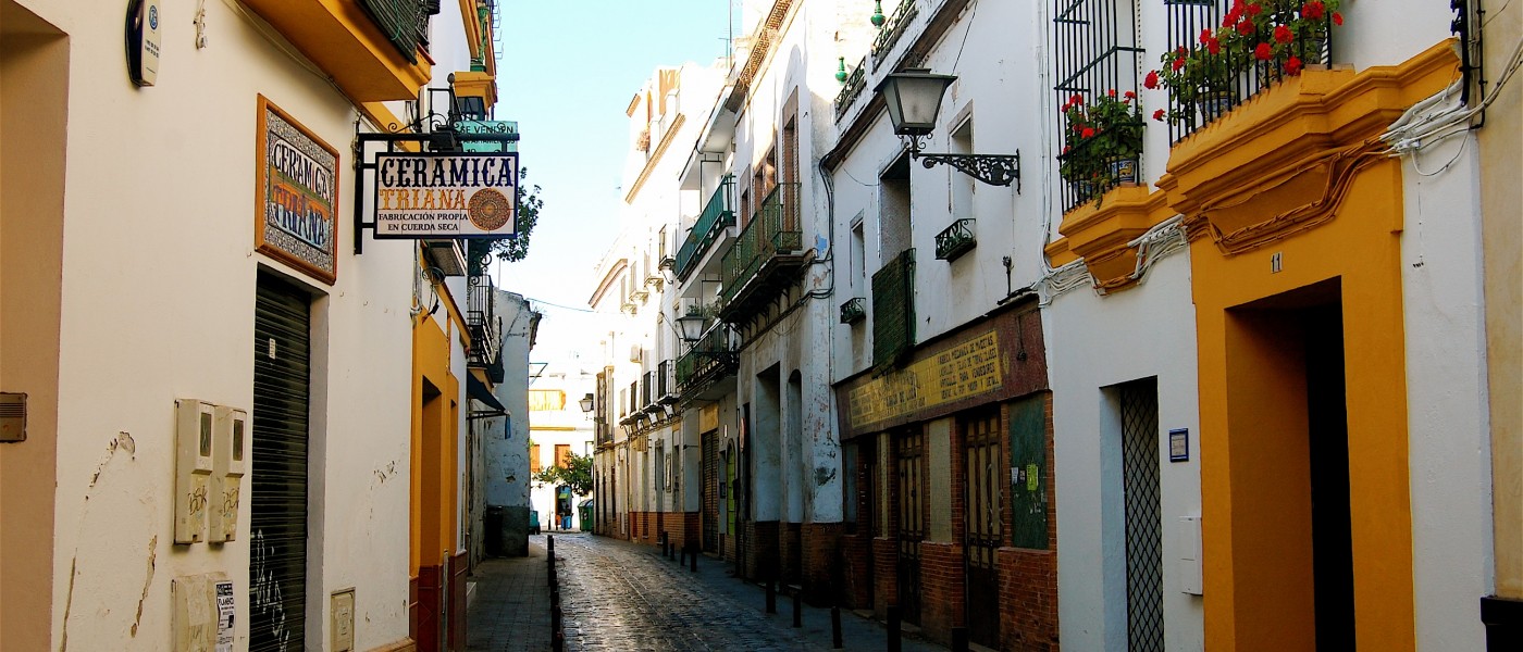 Colorful stucco buildings line narrow Callejón Sevillano in Seville 