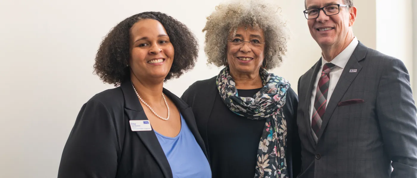Angela Davis poses with U N E's President Herbert and Erica Rousseau