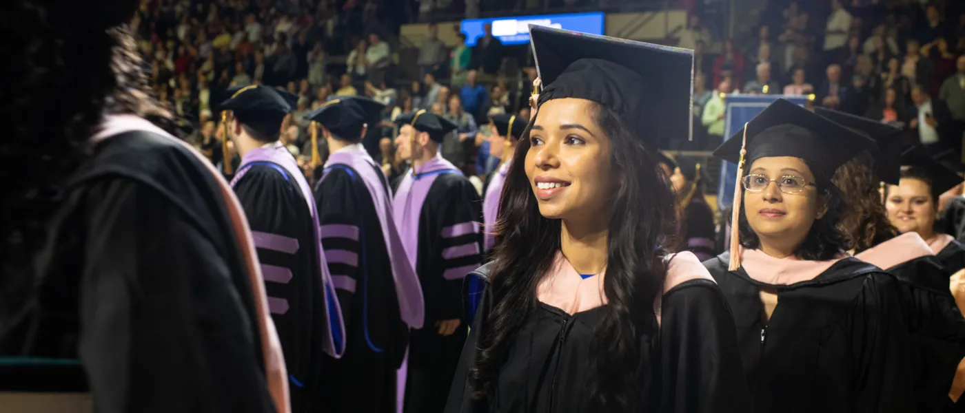 Students walk up to the stage during commencement