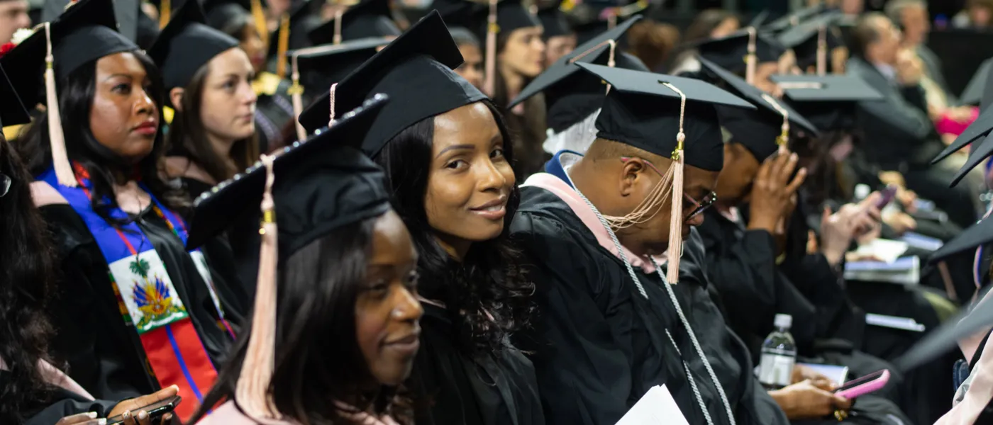 A crowd of students sit with at commencement