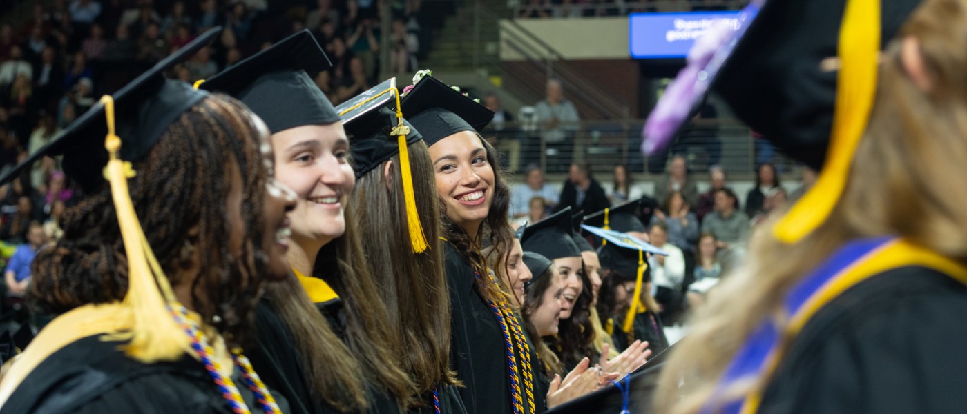 Students stand and talk during commencement
