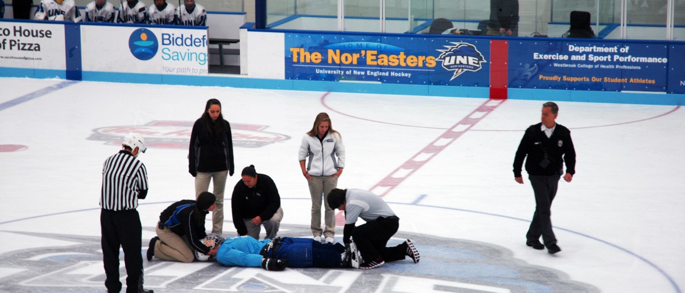 students treat a patient simulator on an ice rink