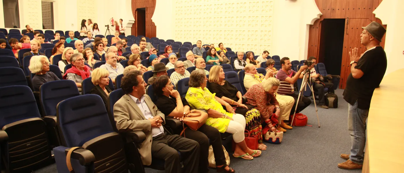 An audience gathers before a theatrical event in the campus theatre.