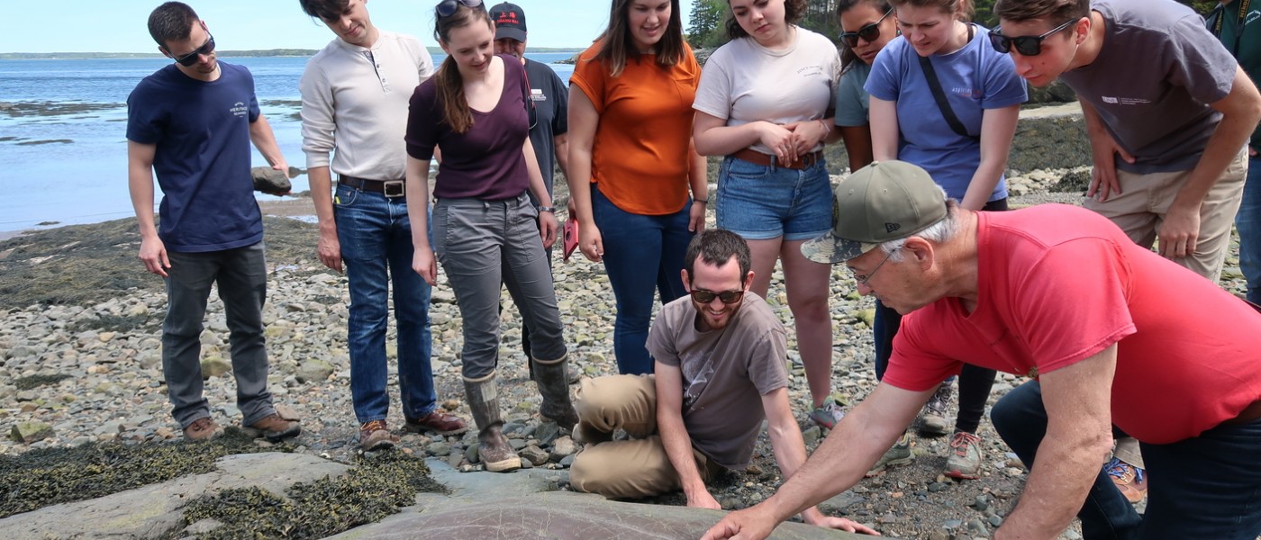 A group of students take samples at the beach