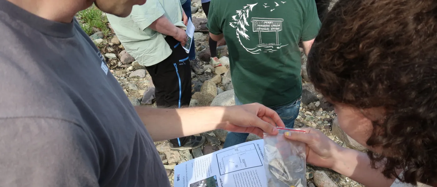 A male students and a female student study a rock
