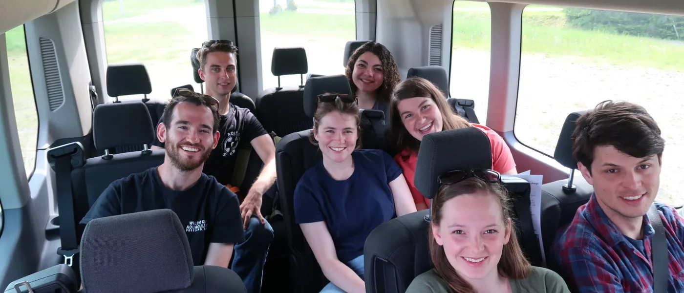 A group of students on a bus smile for the camera