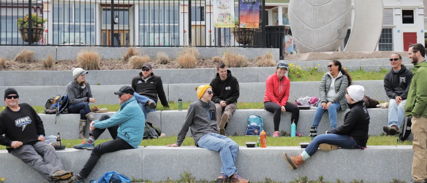 Students sit in a park with stone steps