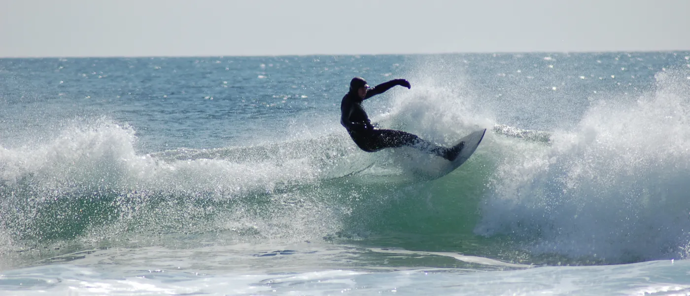 A member of the U N E surf club catches a wave