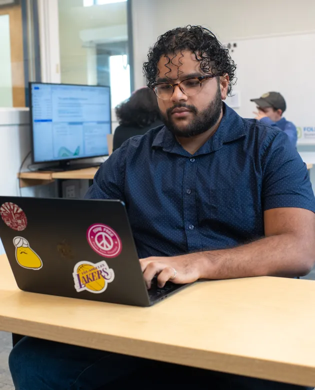 A students types on their laptop