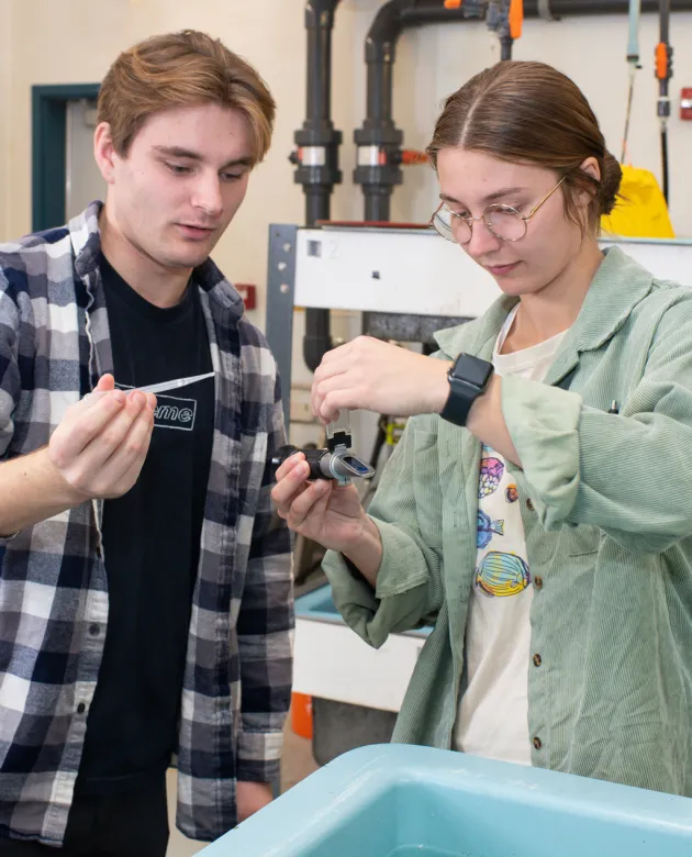 Two students test water in the marine science center