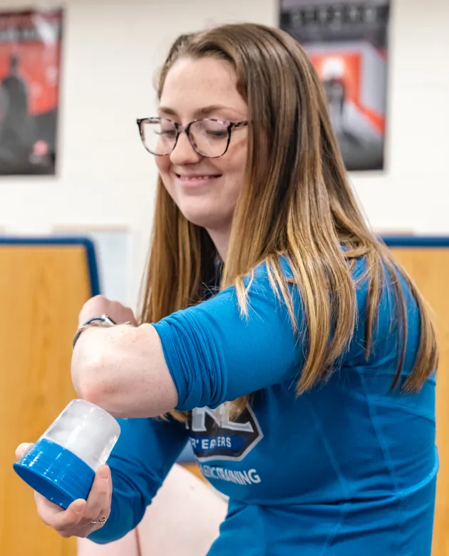 A student practices icing her elbow