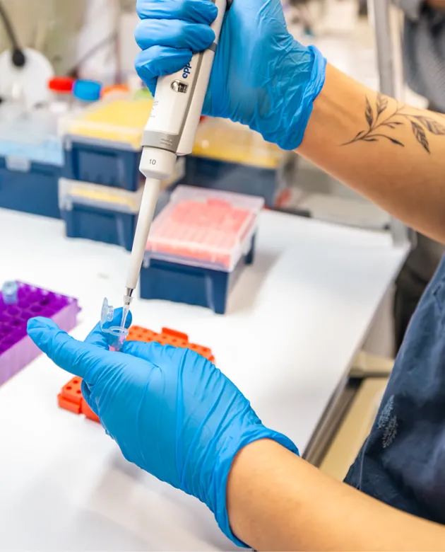 Ruby Motulsky holding a pipet and tube