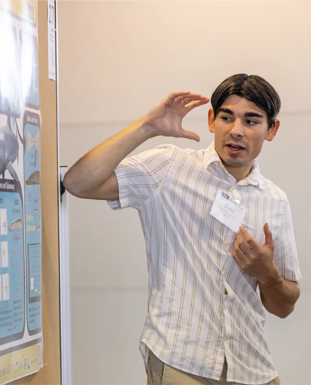 Peter Hennessy, U N E marine science student, presents research at the SURE Fall Reseach Symposium
