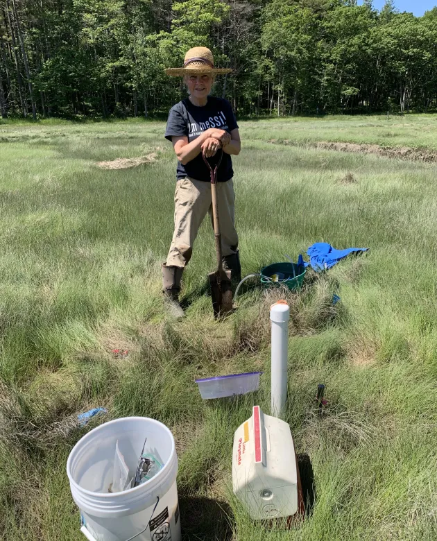 Pam Morgan poses in the field holding a shuttle
