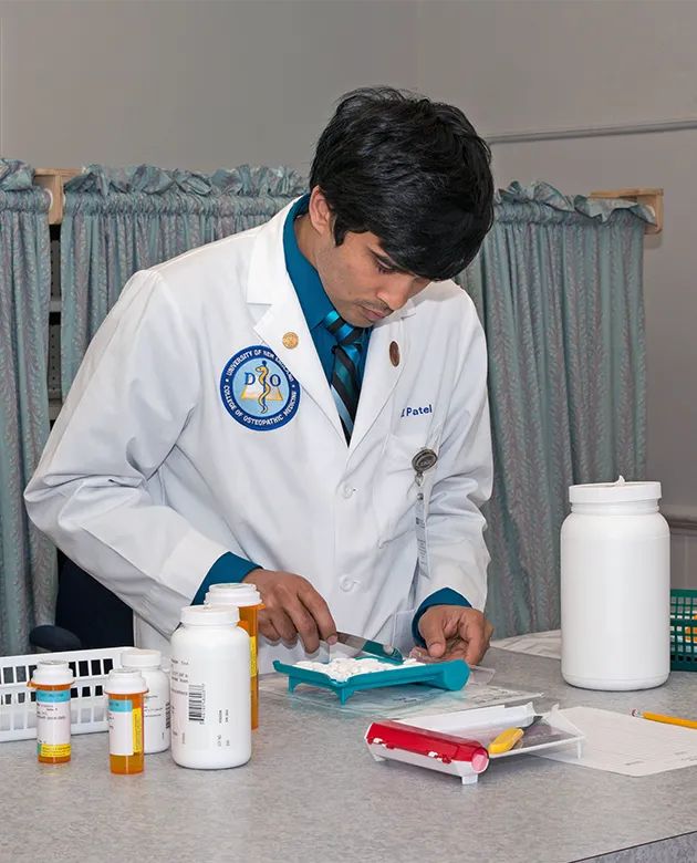 A C O M student prepares medicine for a small clinic