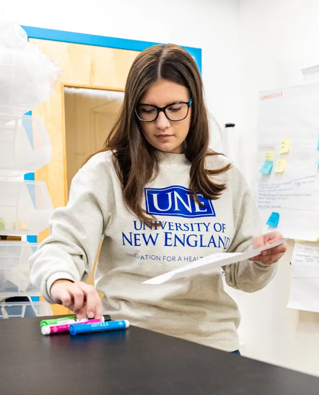 A student chooses from a selection of highlighters while reviewing their notes