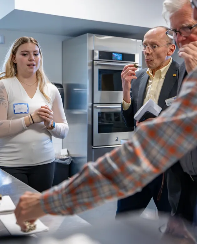 Students from the SeaMade nutrition project chat with taste-testing audience members 