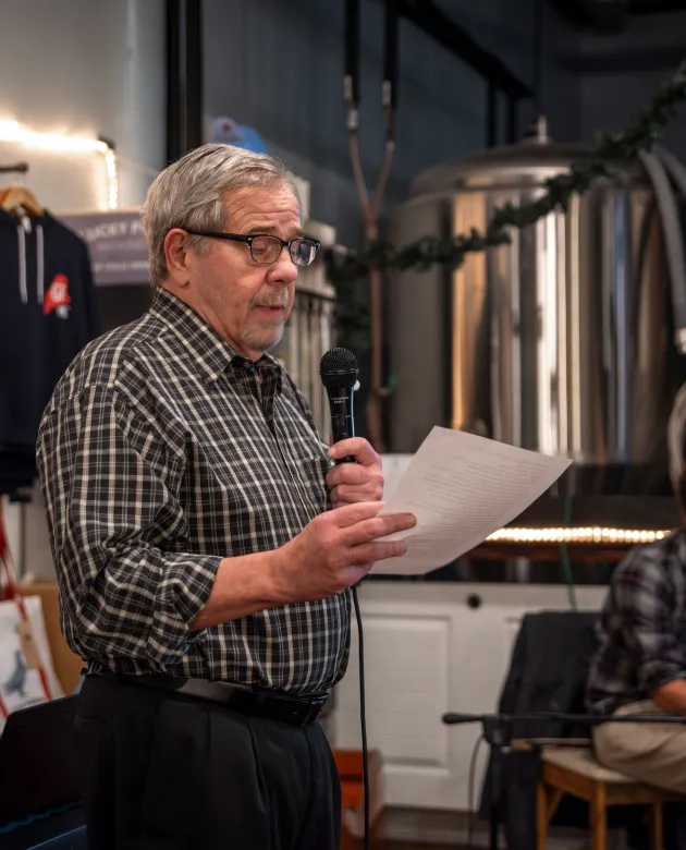 UNE professor Sam McReynolds reads a poem to a crowd