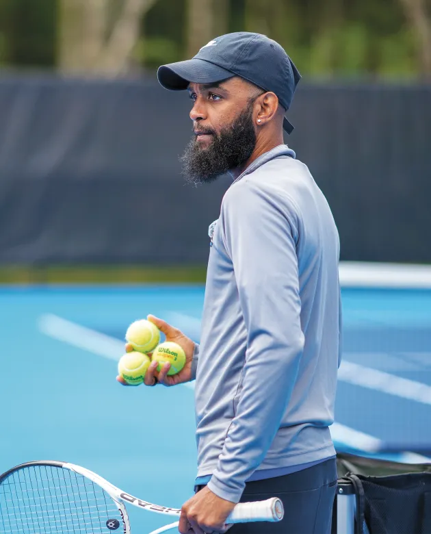 Coach Jovan Jordan-Whitter prepares to serve tennis balls during practice at UNE's outdoor tennis facility on Old Pool Road in Biddeford.