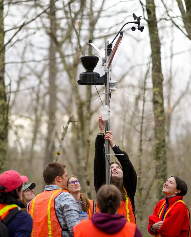 Students place the final components of a forest weather station
