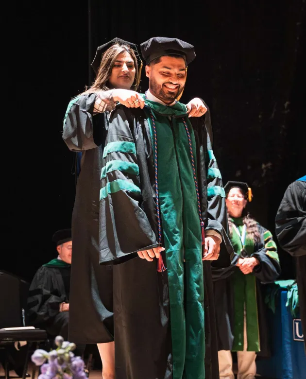 Hafsa Sadiq hood her brother, Hammad, with the Doctor of Osteopathic Medicine stole